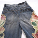 Vaqueros desgastados con borlas y campana