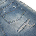 Vaqueros desgastados con borlas y campana