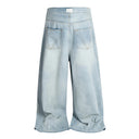 Vaqueros desgastados con borlas y campana