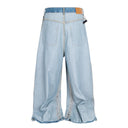 Vaqueros desgastados con borlas y campana